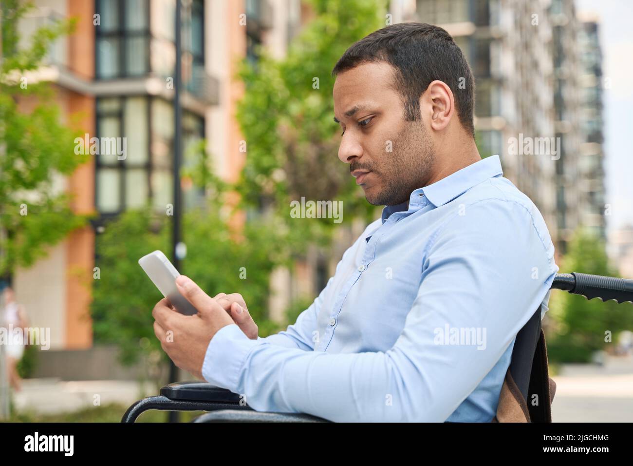Man with disability surfing net from smartphone Stock Photo