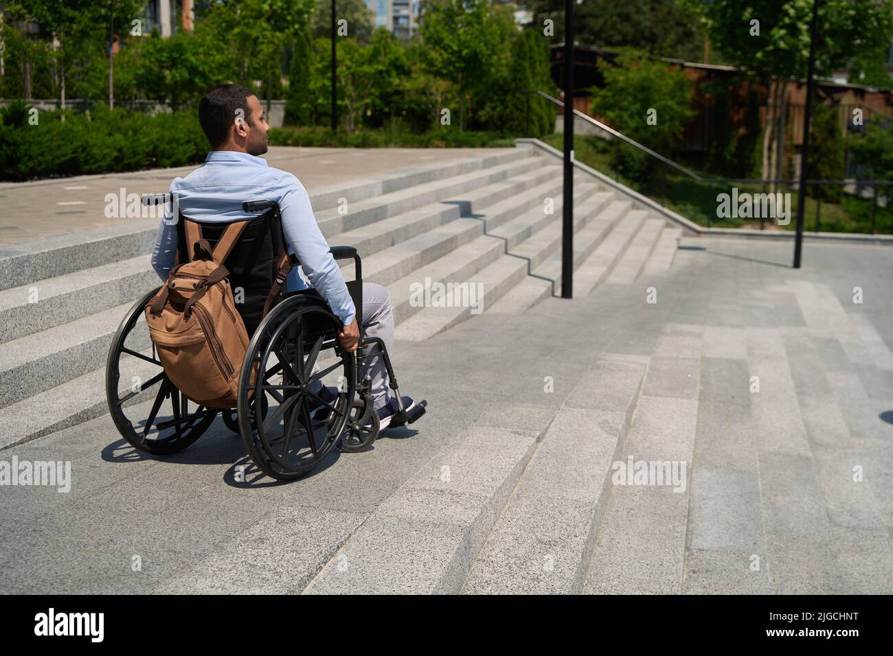 Man seated in manual wheel chair descending staircase Stock Photo
