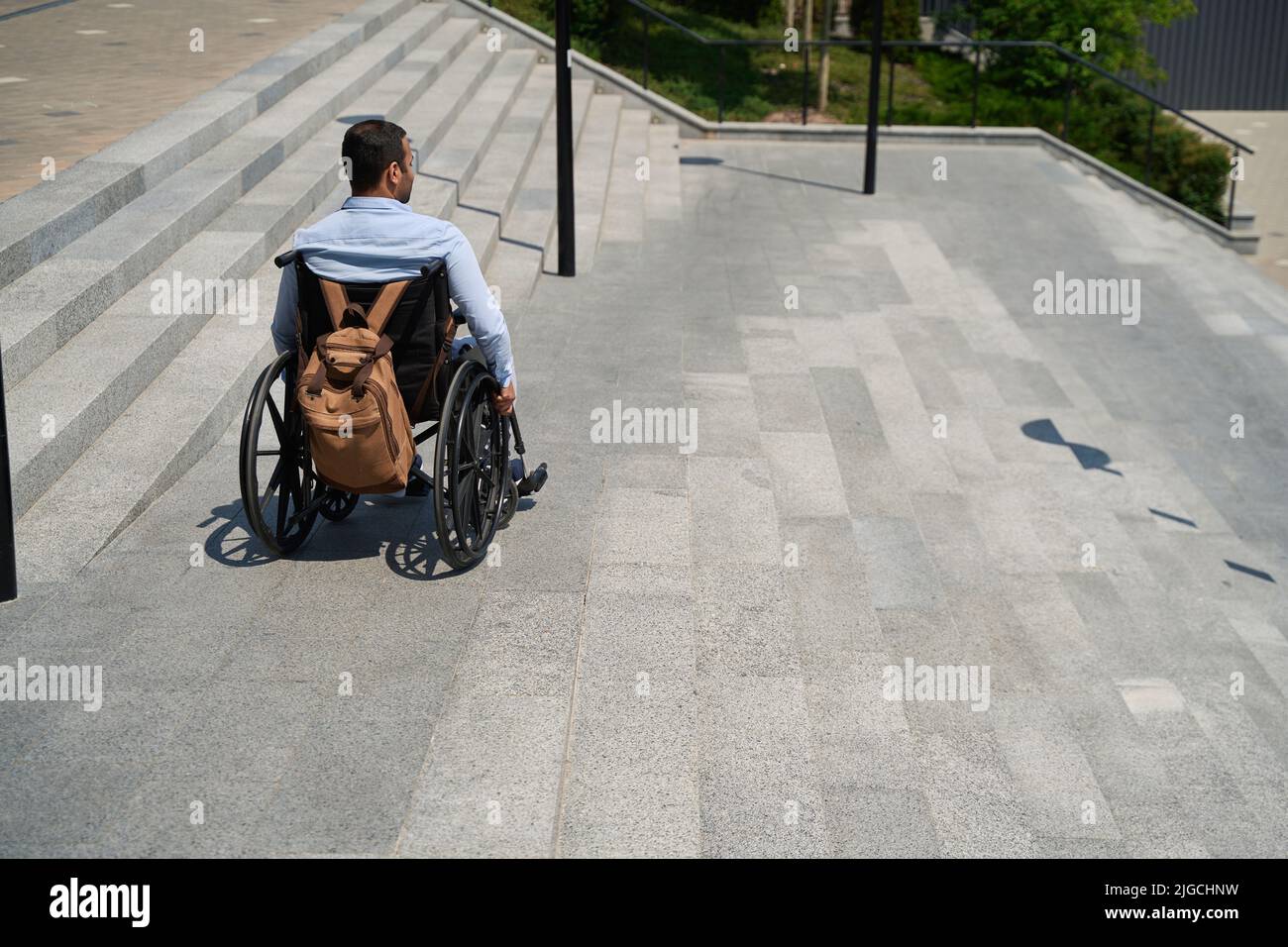 Man with disability descending concrete staircase outdoors Stock Photo