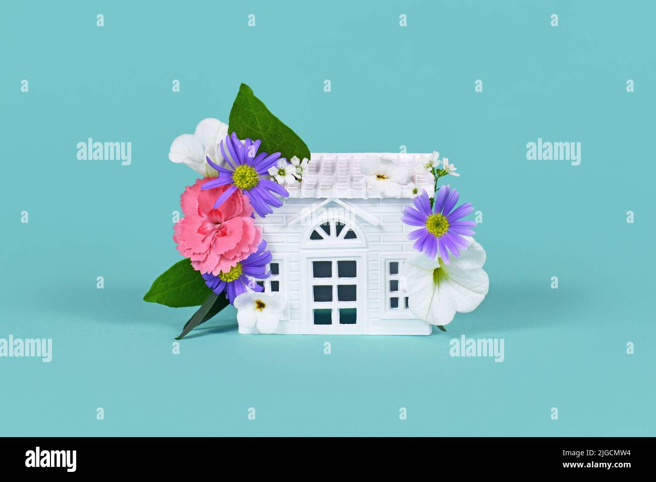 Concept for energy efficiency and carbon neutrality in buildings by using green construction designs and renewable energy showing house with flowers Stock Photo