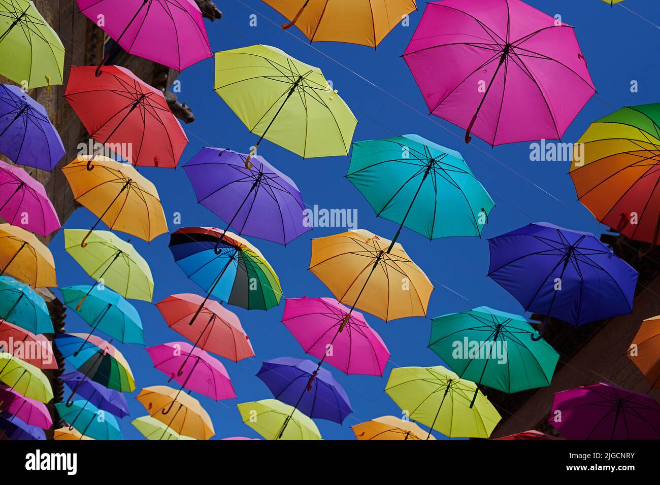 Beautiful coluorful umbrellas hanging across a typical street in the