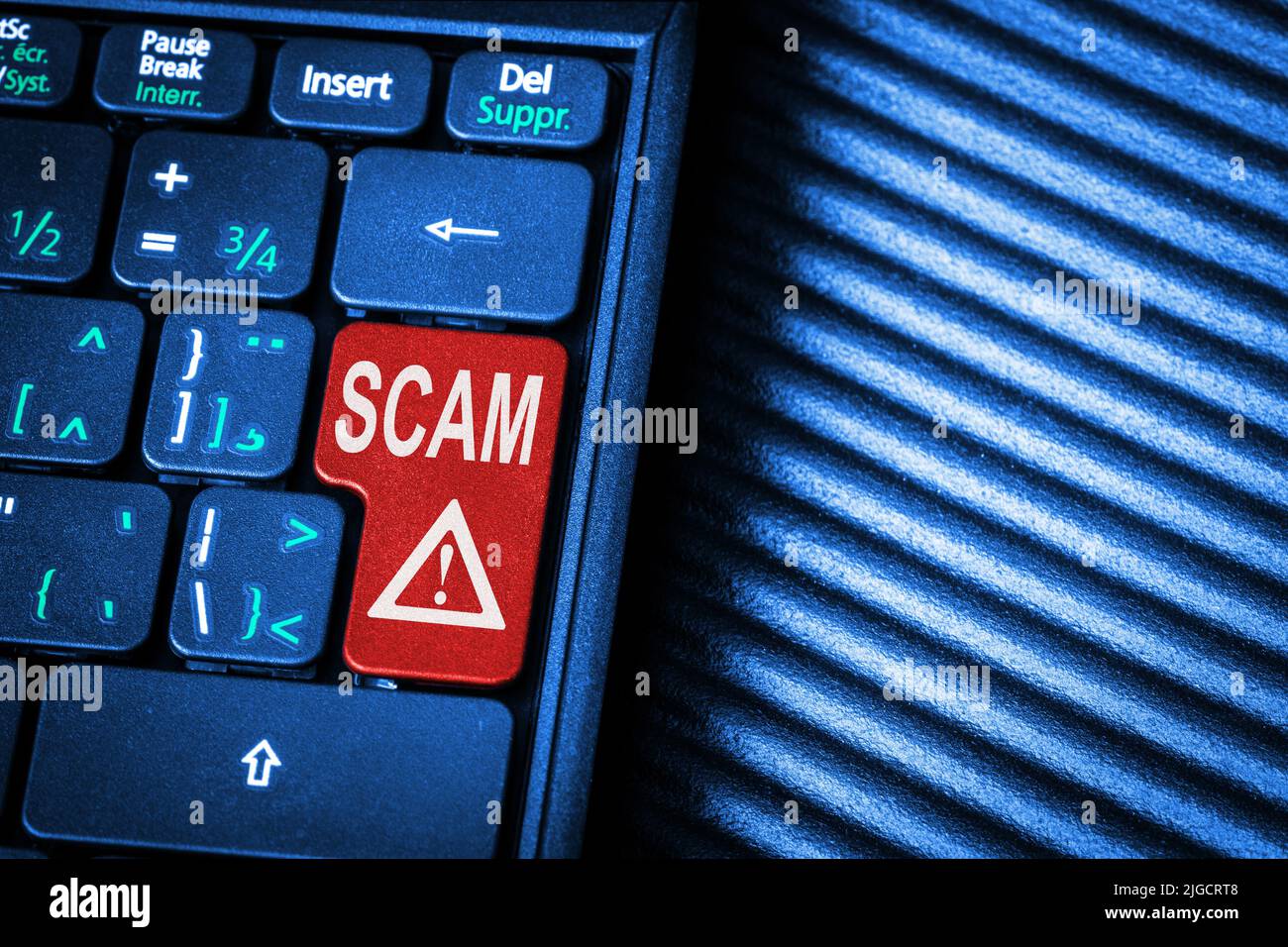 Keyboard showing a red key and the message scam alert with copy space. Concept of high-tech scam and Internet danger with the touch of a button. Stock Photo