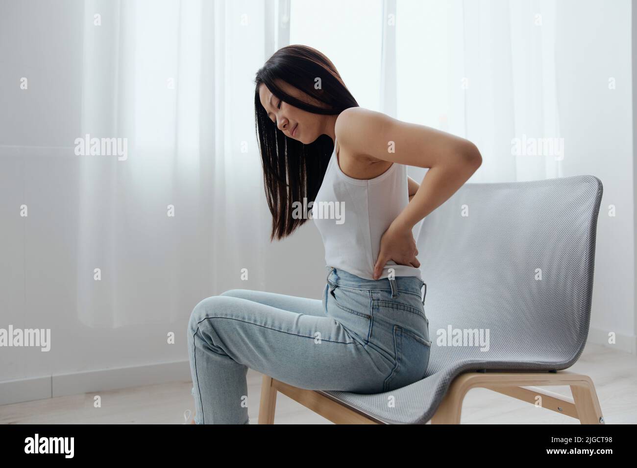 Suffering from scoliosis osteochondrosis after long study pretty young Asian woman feel hurt