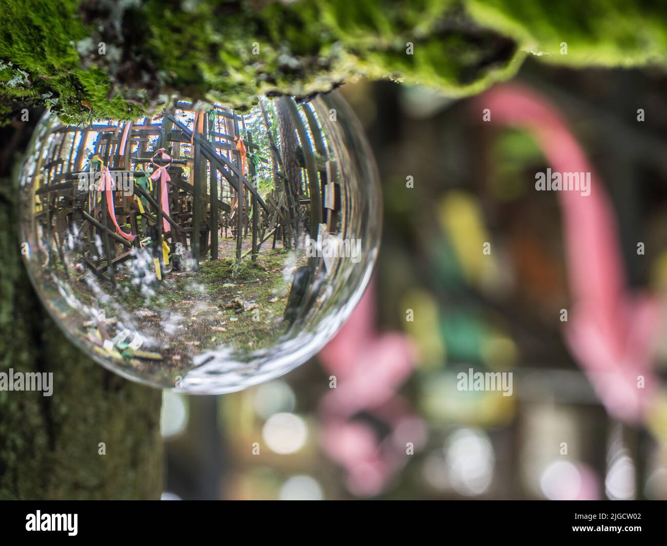Holly crosses brought by pilgrims to the Holy Mount Grabarka reflecting in the glass ball. Poland. Grabarka. Stock Photo