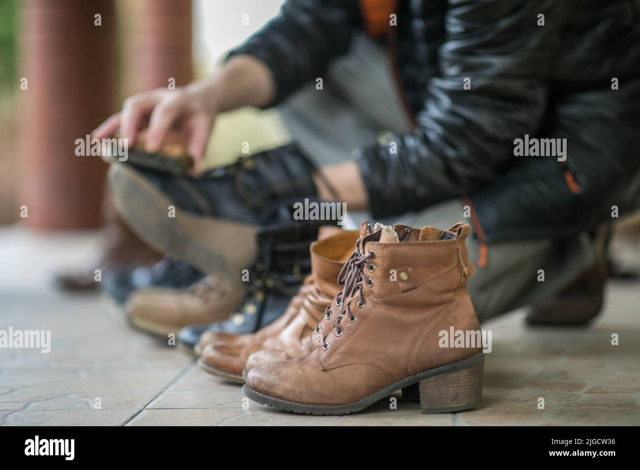 The man's hands  polishing the shoes on the terrace during the spring time Stock Photo
