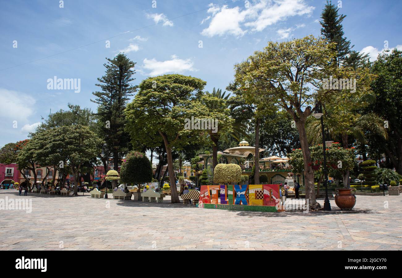 panorama of magic town Atlixco Zocalo main square park with view to the church at the background and traditional city letters, Atlixco, Puebla, Mexico Stock Photo