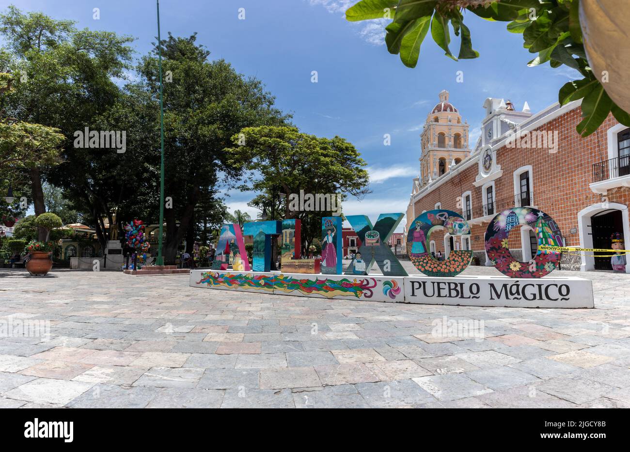 panorama of magic town Atlixco Zocalo main square park with view to the church at the background and traditional city letters, Puebla, Mexico Stock Photo