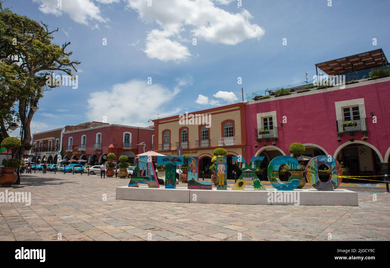 panorama of magic town Atlixco Zocalo main square park with view to the church at the background and traditional city letters, Puebla, Mexico Stock Photo