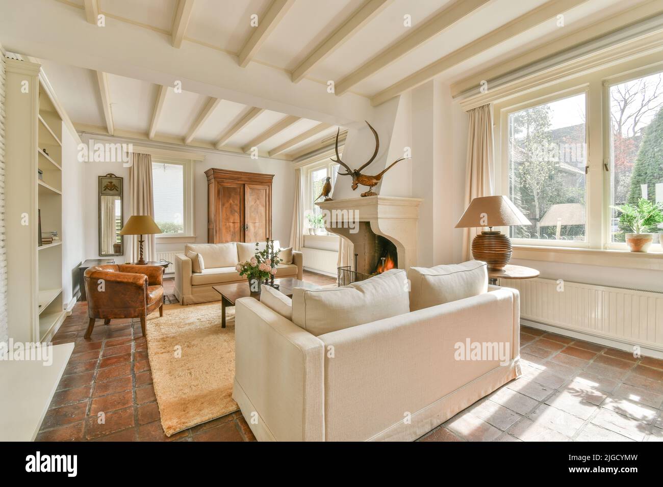 Contemporary open plan kitchen with dining table set and gray sofa in