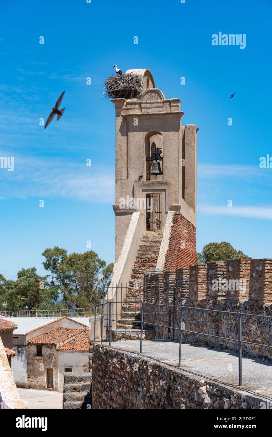 Bell tower in the wall that surrounds the town of Galisteo, with a nest of storks. Stock Photo