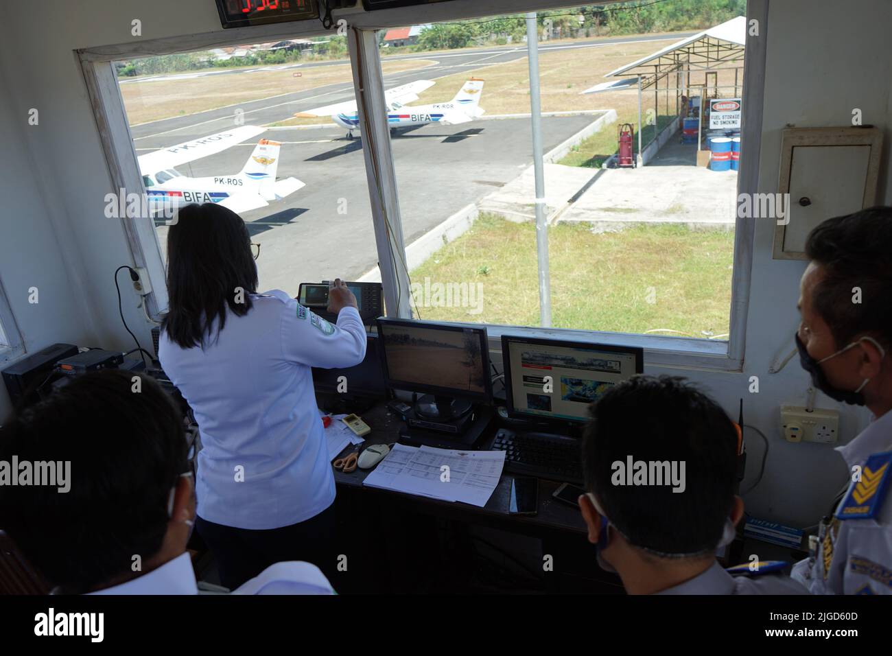 Buleleng,Sept 2 2022: an air traffic controller on duty at the pioneering airport of Lieutenant Colonel Wisnu, North Bali. she is preparing to give fl Stock Photo
