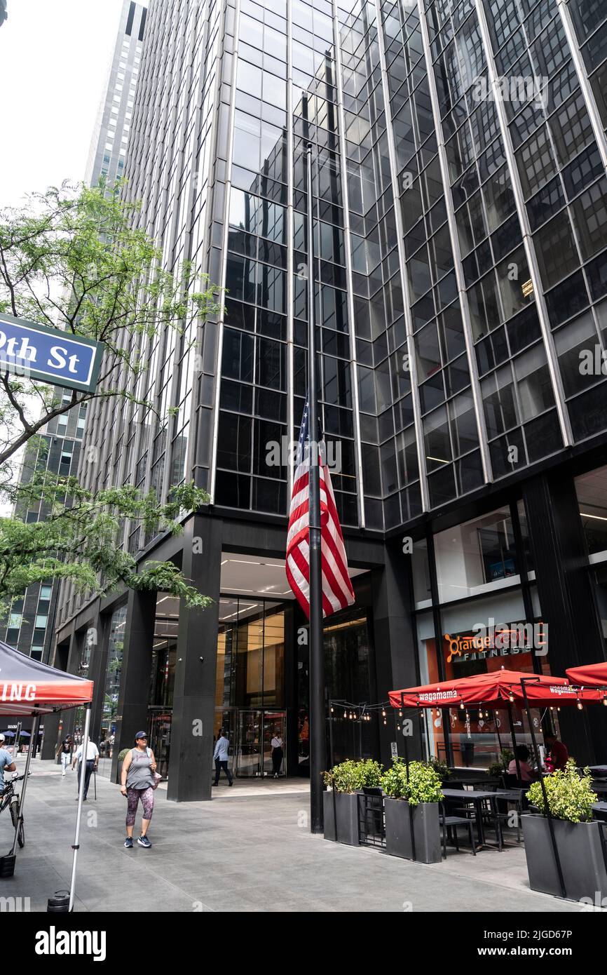 New York, NY - July 8, 2022: American flags lowered at building on 695 3rd Ave where UN Japanese Mission located after assassination of former PM of Japan Shinzo Abe Stock Photo