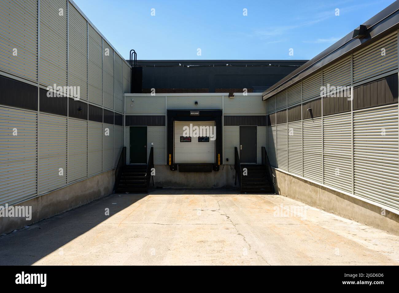 Warehouse loading door an end of a sloped concrete drive. Stock Photo