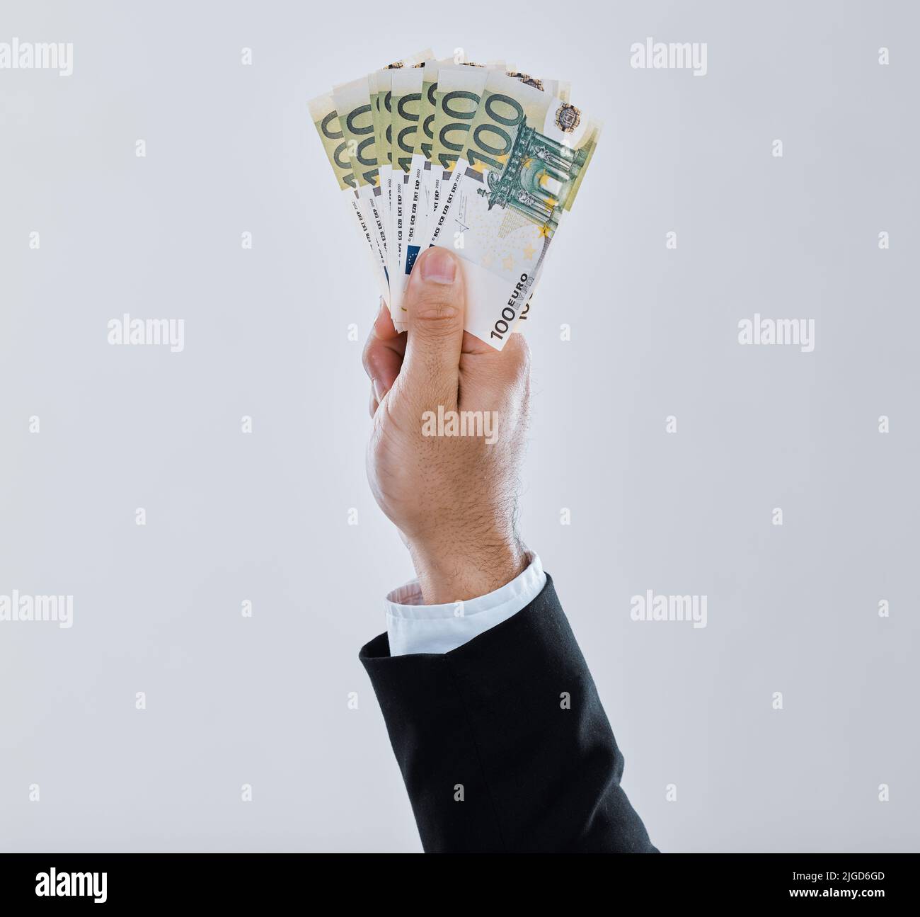Power doesnt corrupt people, people corrupt power. a businessman stretching out his hand holding money against a grey background. Stock Photo