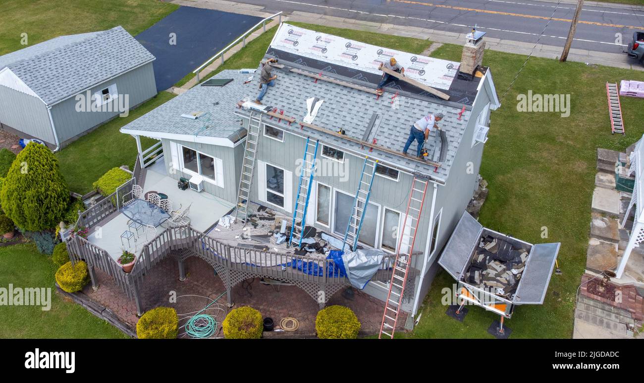 Roofers retiling the roof of a home in Athens, Greene County, New York, USA Stock Photo
