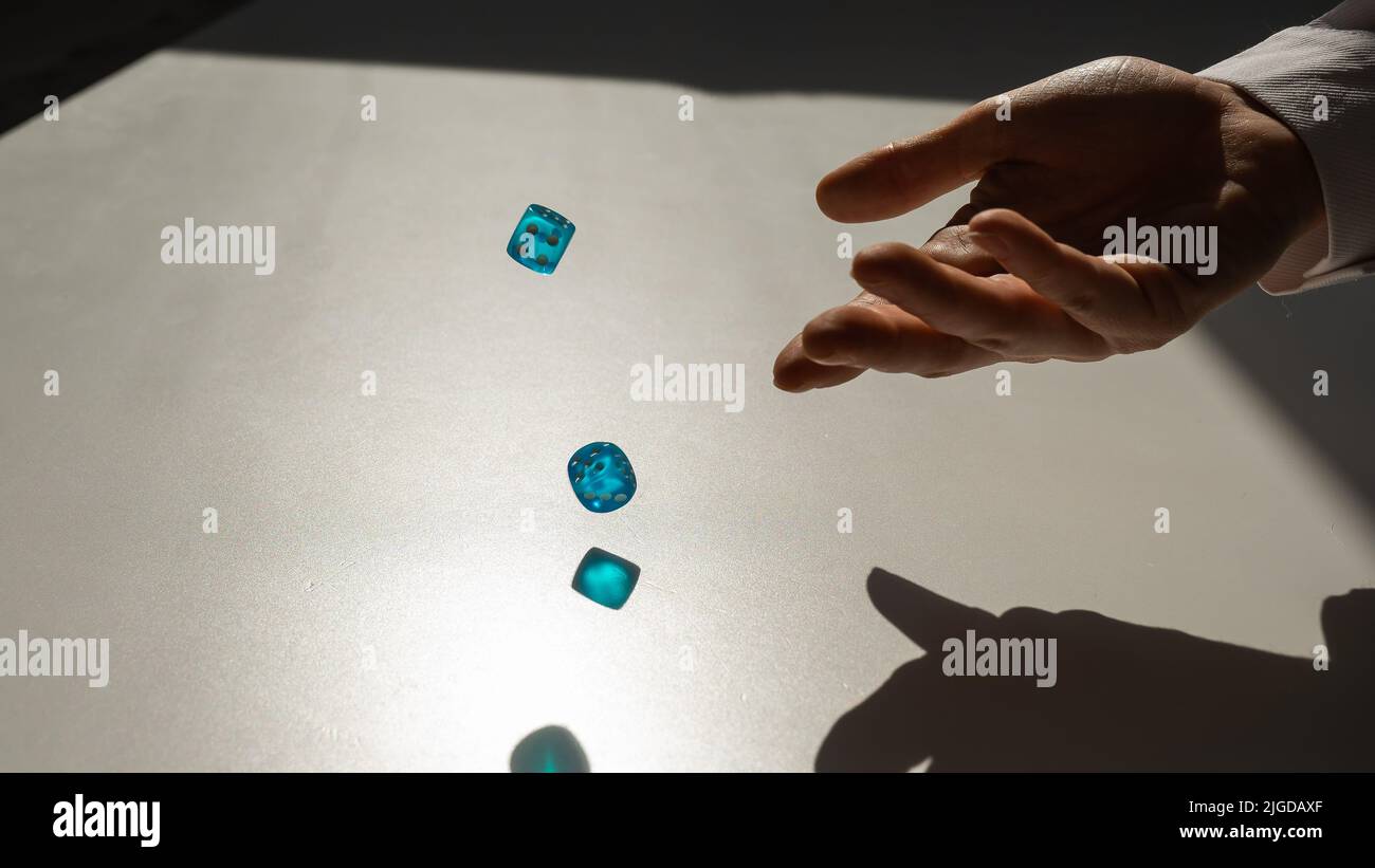 Woman throws a pair of blue transparent dice Stock Photo Alamy