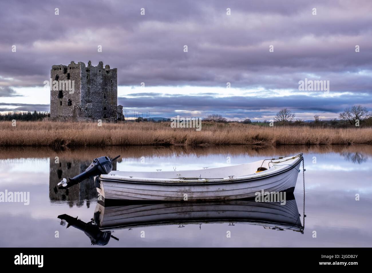 Boat moored on the river dee with Threave Castle in the background, Castle Douglas, Scotland Stock Photo
