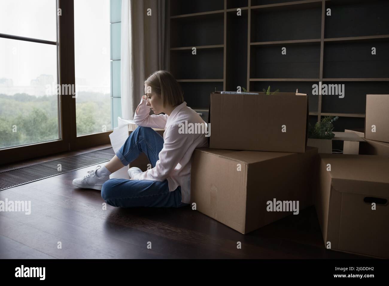 Sad lonely young renter woman moving out from home Stock Photo