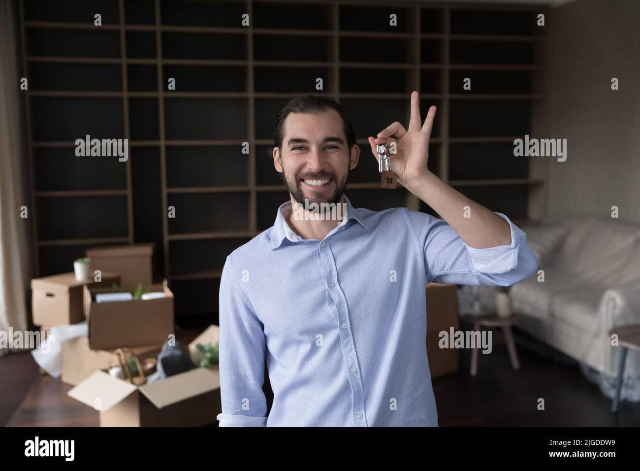 Happy proud house buyer man shaking, holding keys Stock Photo