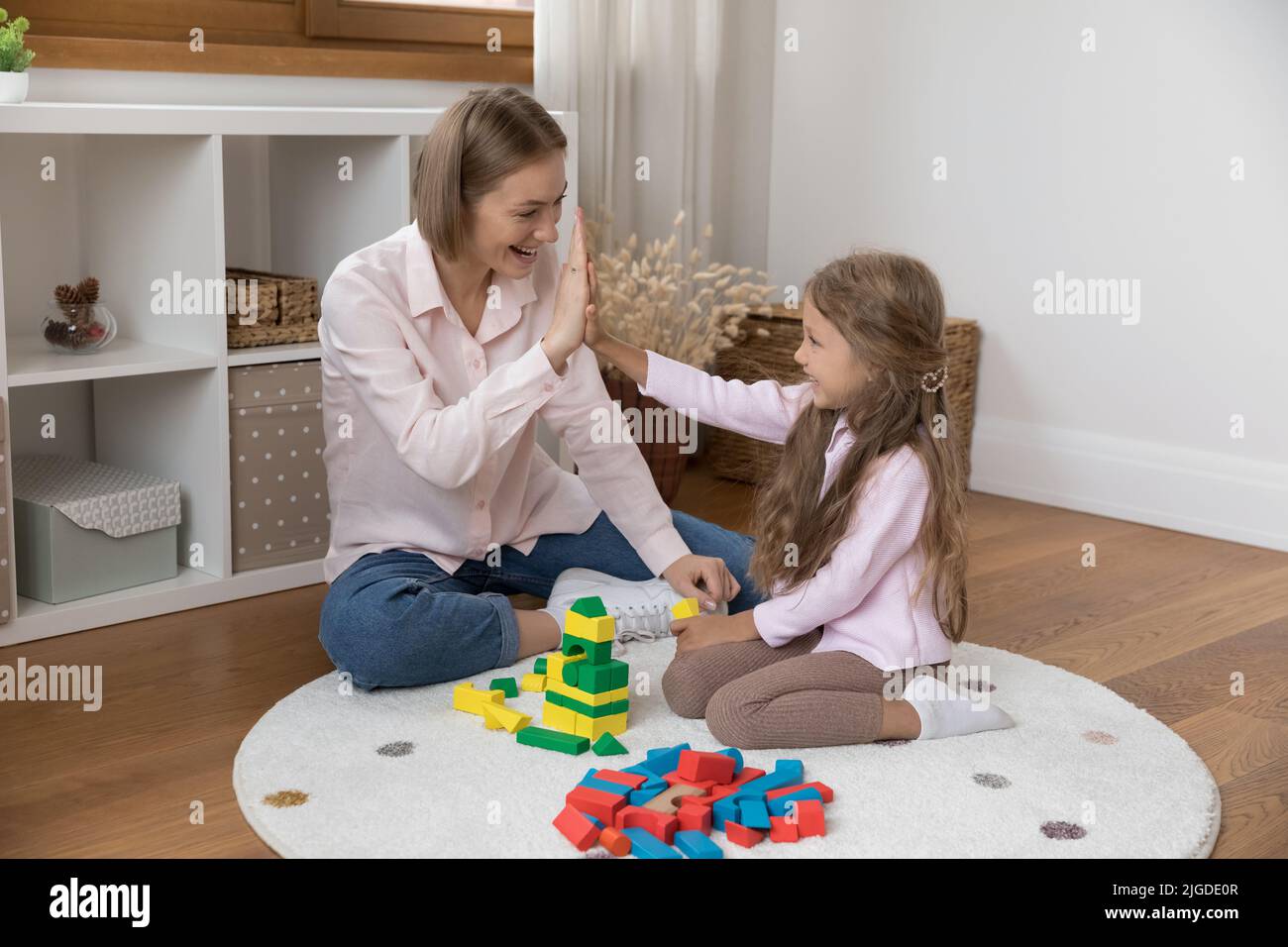 Happy young mom and little daughter kid clapping hands Stock Photo - Alamy
