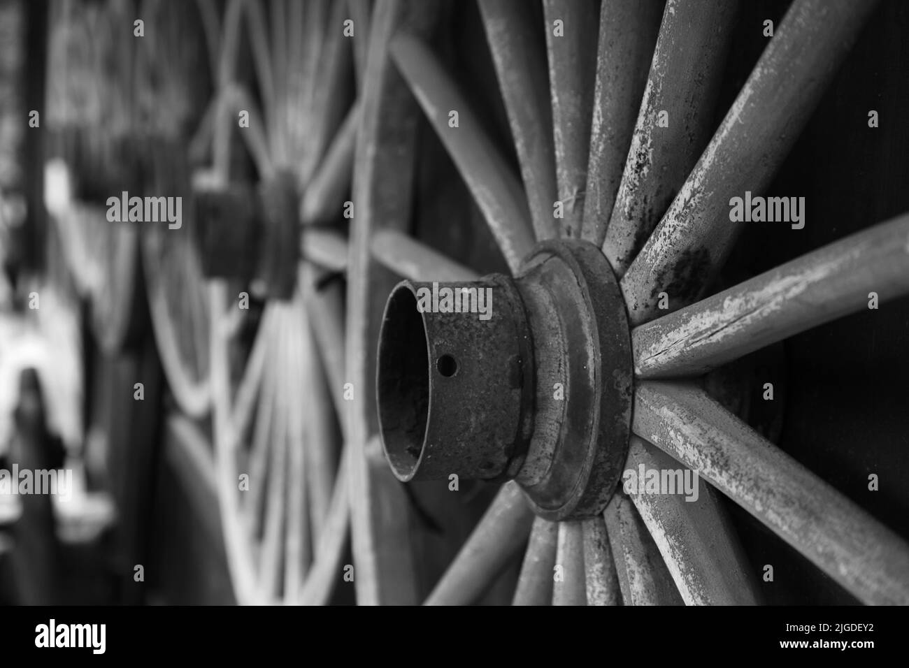 Closeup of some traditional wooden spoked wagon wheels hanging on a wall in Takayama Japan. Black and White Stock Photo