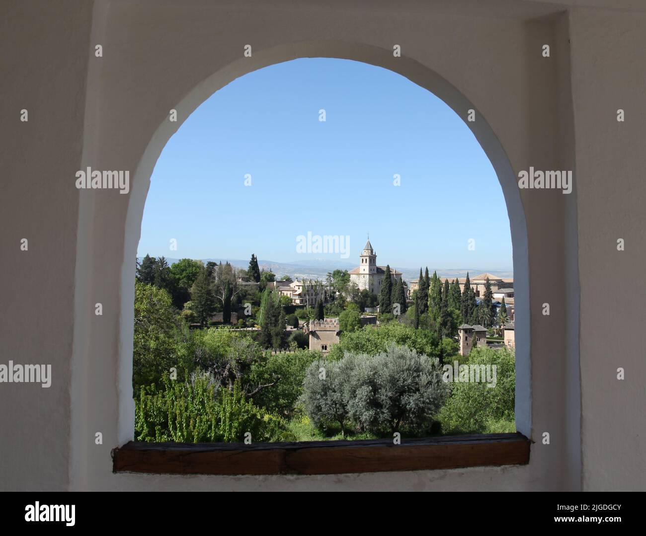 Alhambra seen through a window in the Generalife gardens. Santa Maria church bell tower. Granada Spain Stock Photo
