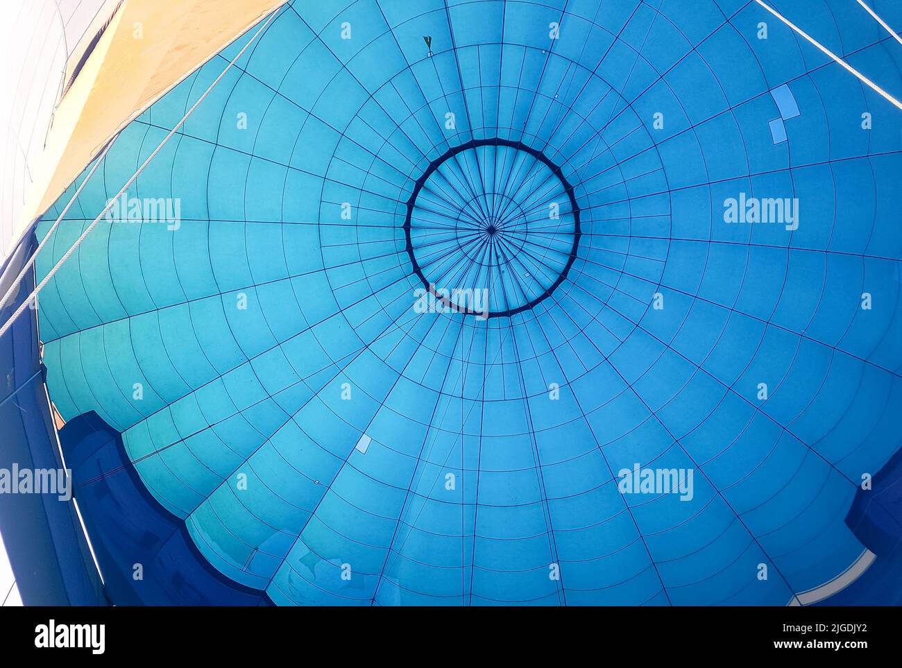 Hot air balloon from the inside. Blue balloon fabric with ropes. A moment before a flight when you're looking up. Stock Photo