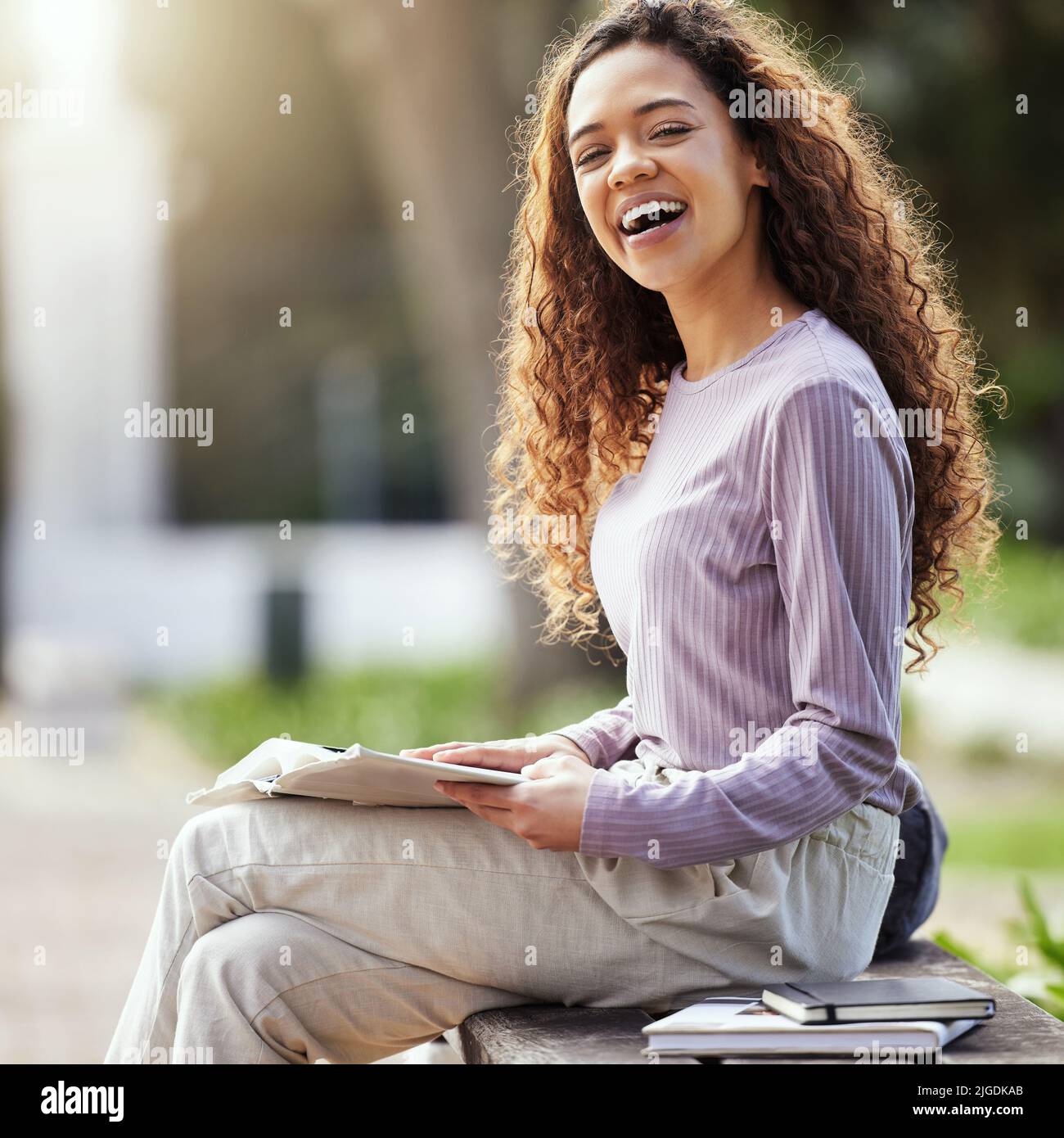 Student life is treating me well. a young female student studying in nature. Stock Photo