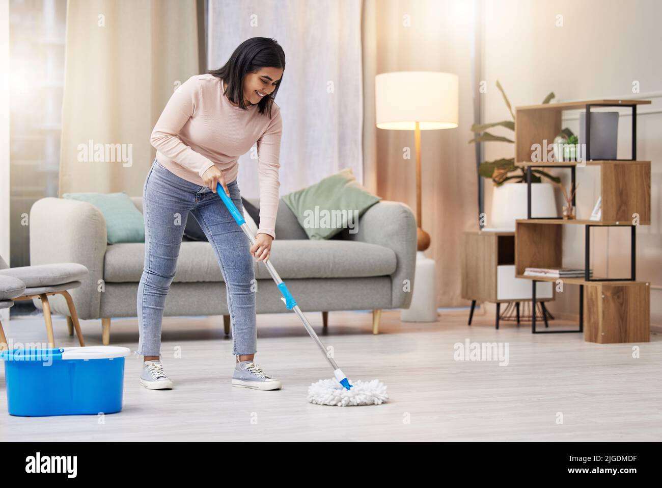 It looks so much better now. a young woman mopping the floors at home. Stock Photo