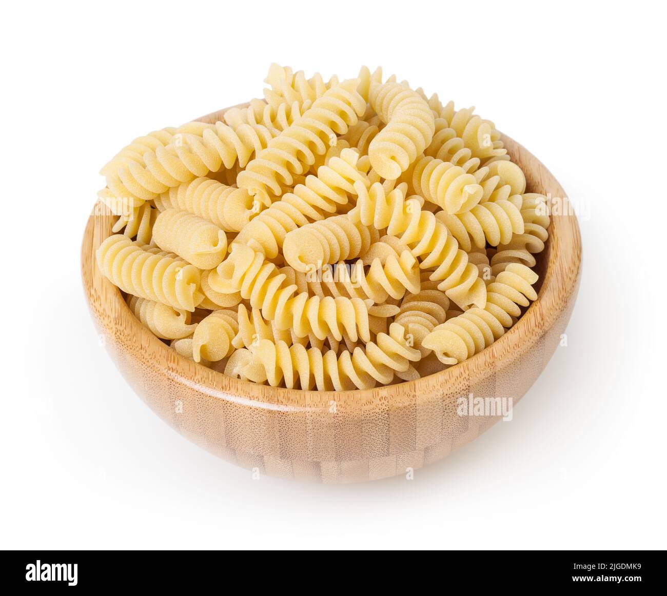 Uncooked fusilli pasta in wooden bowl isolated on white background with