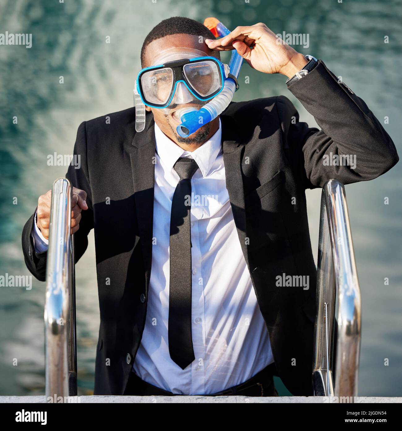 No longer drowning in debt. a businessman getting out of a pool while wearing scuba diving gear. Stock Photo
