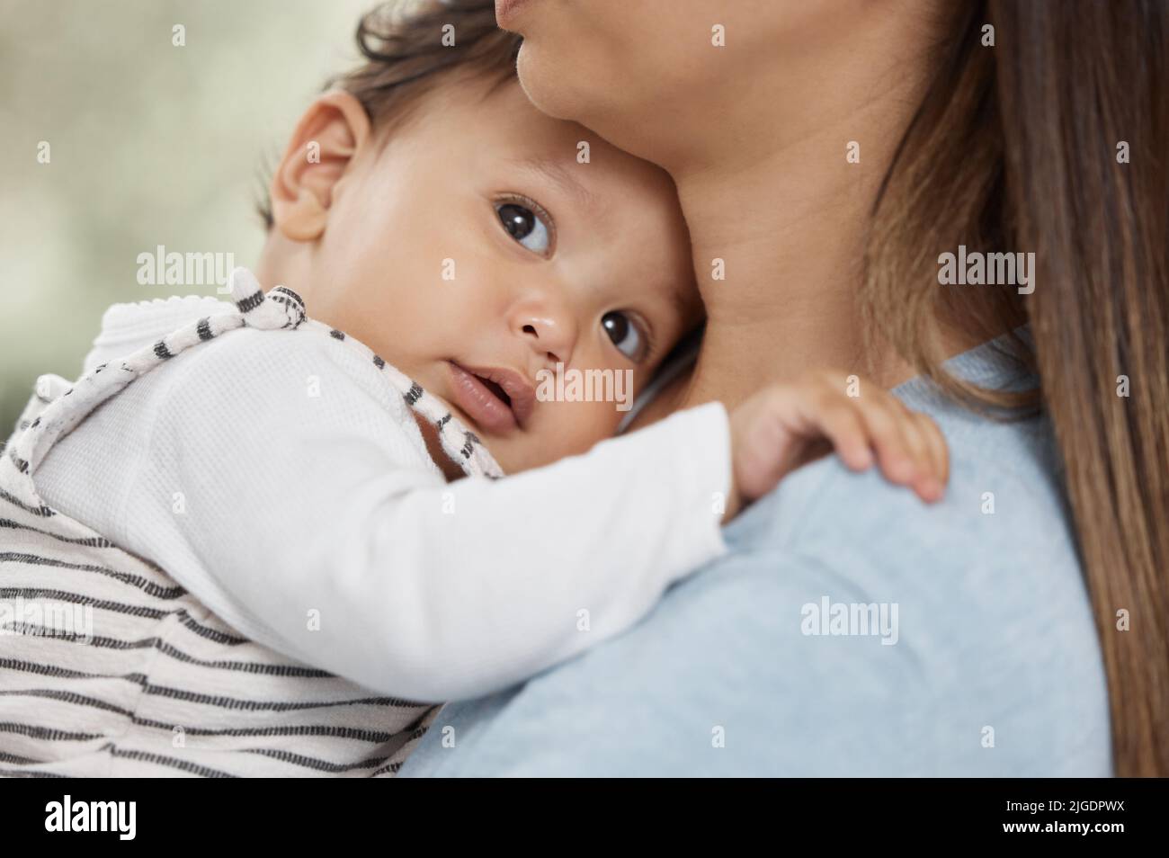a baby eating a meal at home. a mother holding her baby at home. Stock Photo