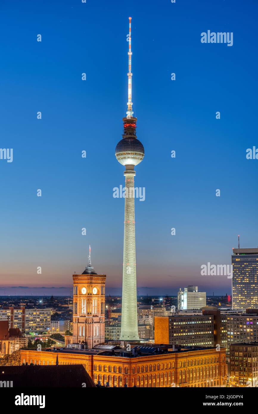 The iconic TV Tower of Berlin with the town hall at night Stock Photo