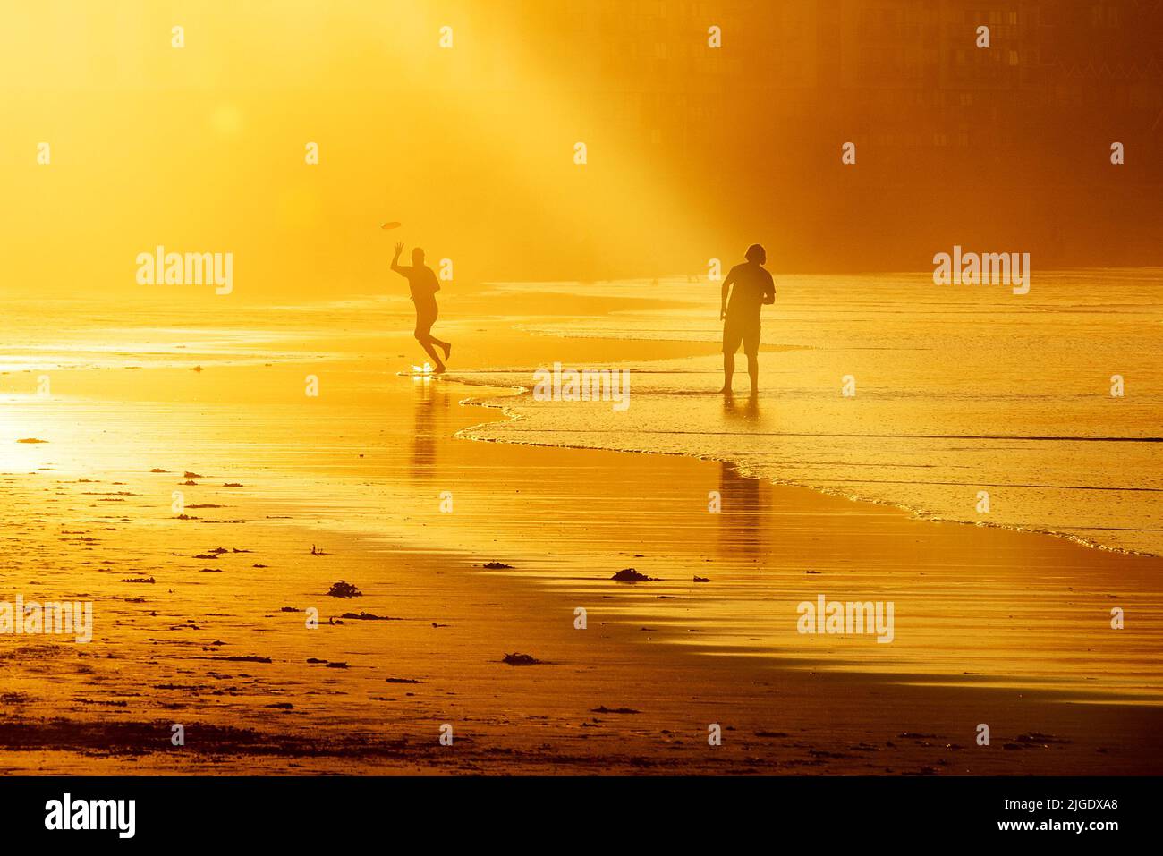 Scarborough, North Yorkshire, UK. 9th Jul 2022. People play frisbee in the late evening sun on North Bay beach at Scarborough, North Yorkshire. Neil Squires/Alamy Live News Stock Photo