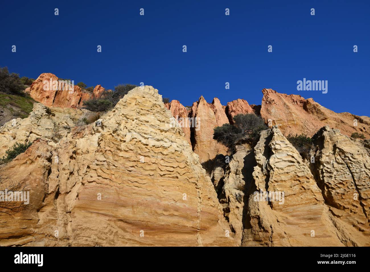 Close view of reddish jagged sandstone formations that make up part of Red Bluff, a natural landmark in metropolitan Melbourne Stock Photo