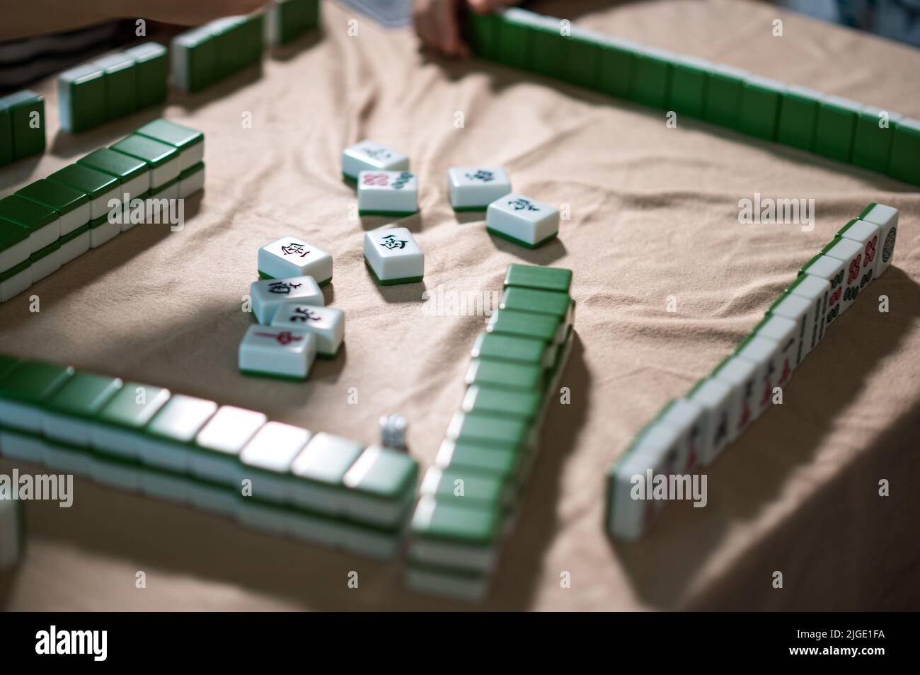 Female friends playing mahjong traditional Chinese board game at home