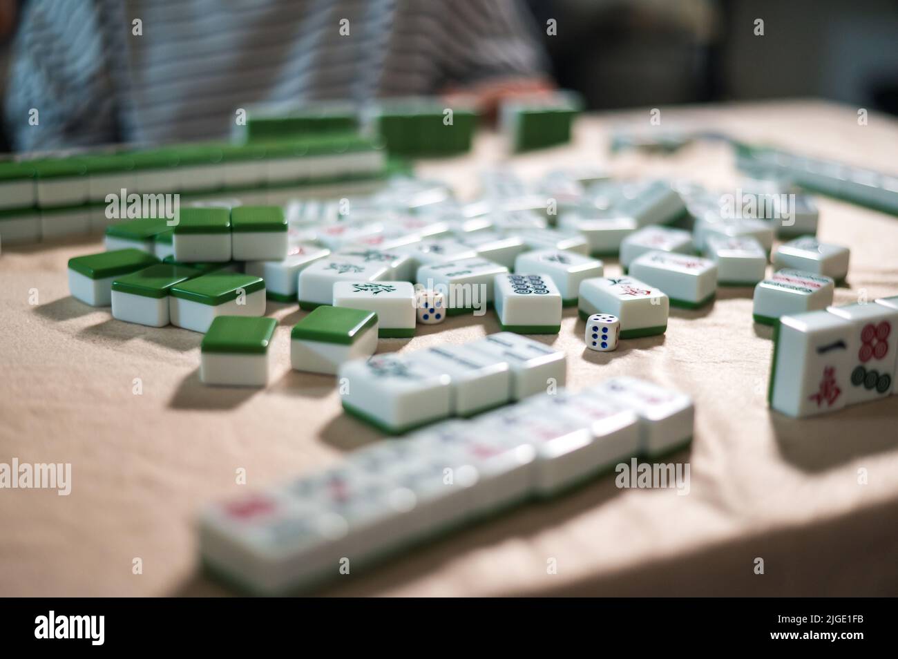 Female friends playing mahjong traditional Chinese board game at home