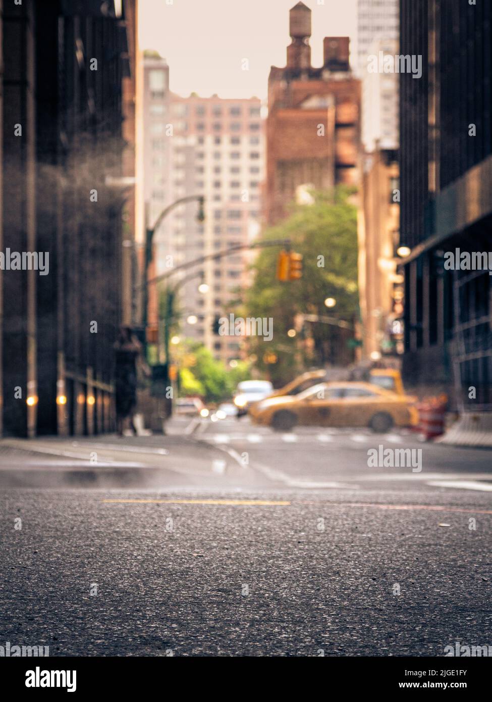 A shot of the street in New York City. A picture that typifies the Big Apple for me  tall buildings, yellow cabs, the haze from the underground etc. Stock Photo