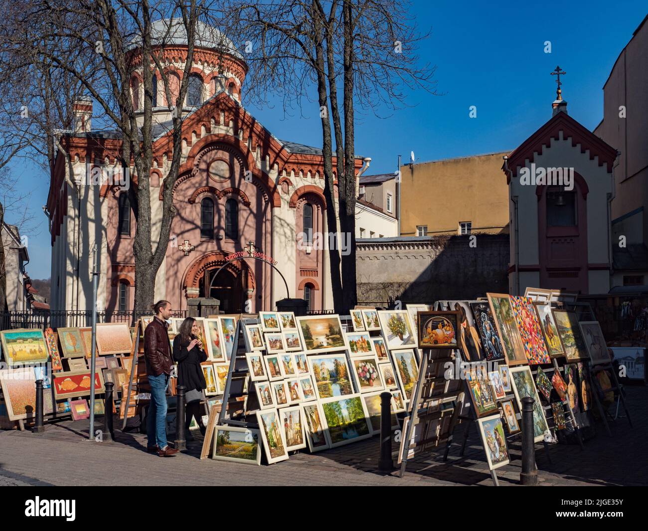 Vilnius, Lithuania - April 2018: Stands with paintings sold by artists on the street  near Eastern Orthodox Church of St. Paraskeva,  Eastern. Europe Stock Photo