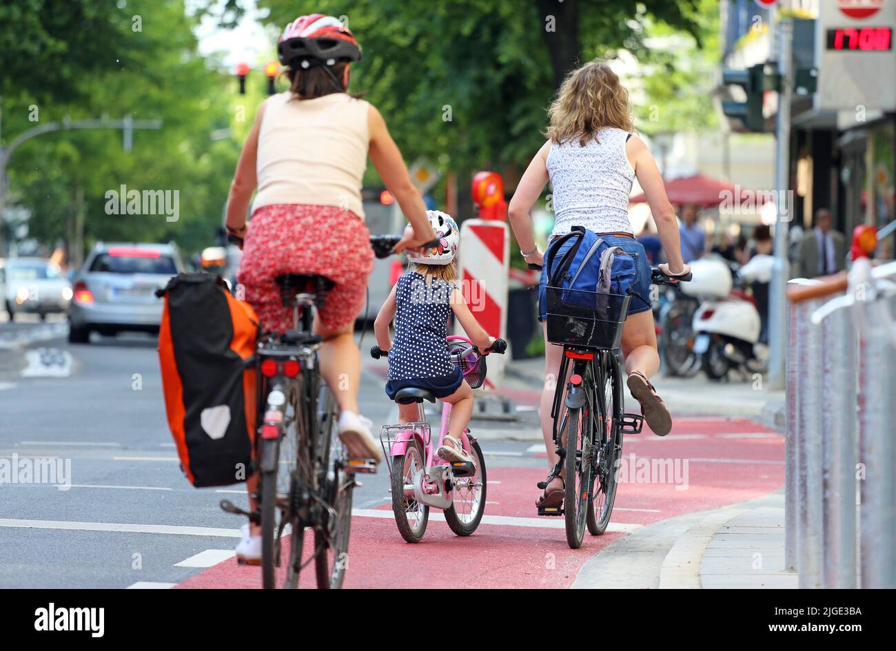 mother with little daughter on bike lane Stock Photo