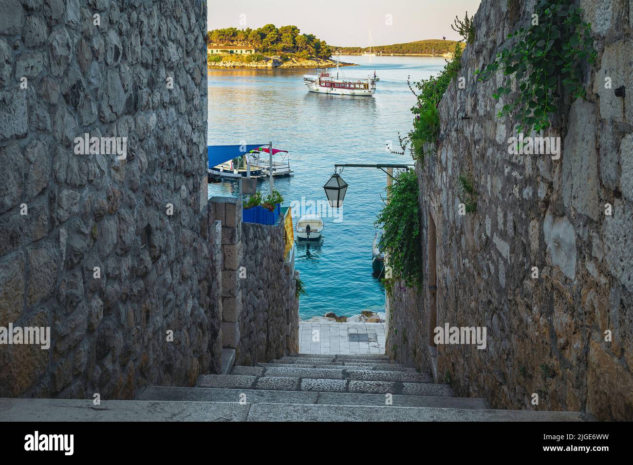 Anchored ships and boats in the small marina view from the narrow street, Hvar, Dalmatia, Croatia, Europe Stock Photo