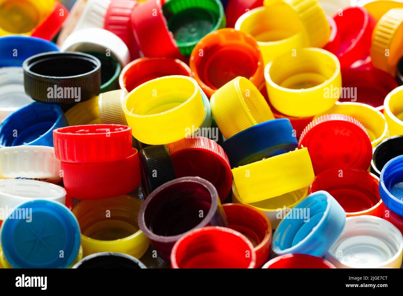 Caps from plastic bottles. Lots of colorful plastic bottle caps. Product of the chemical