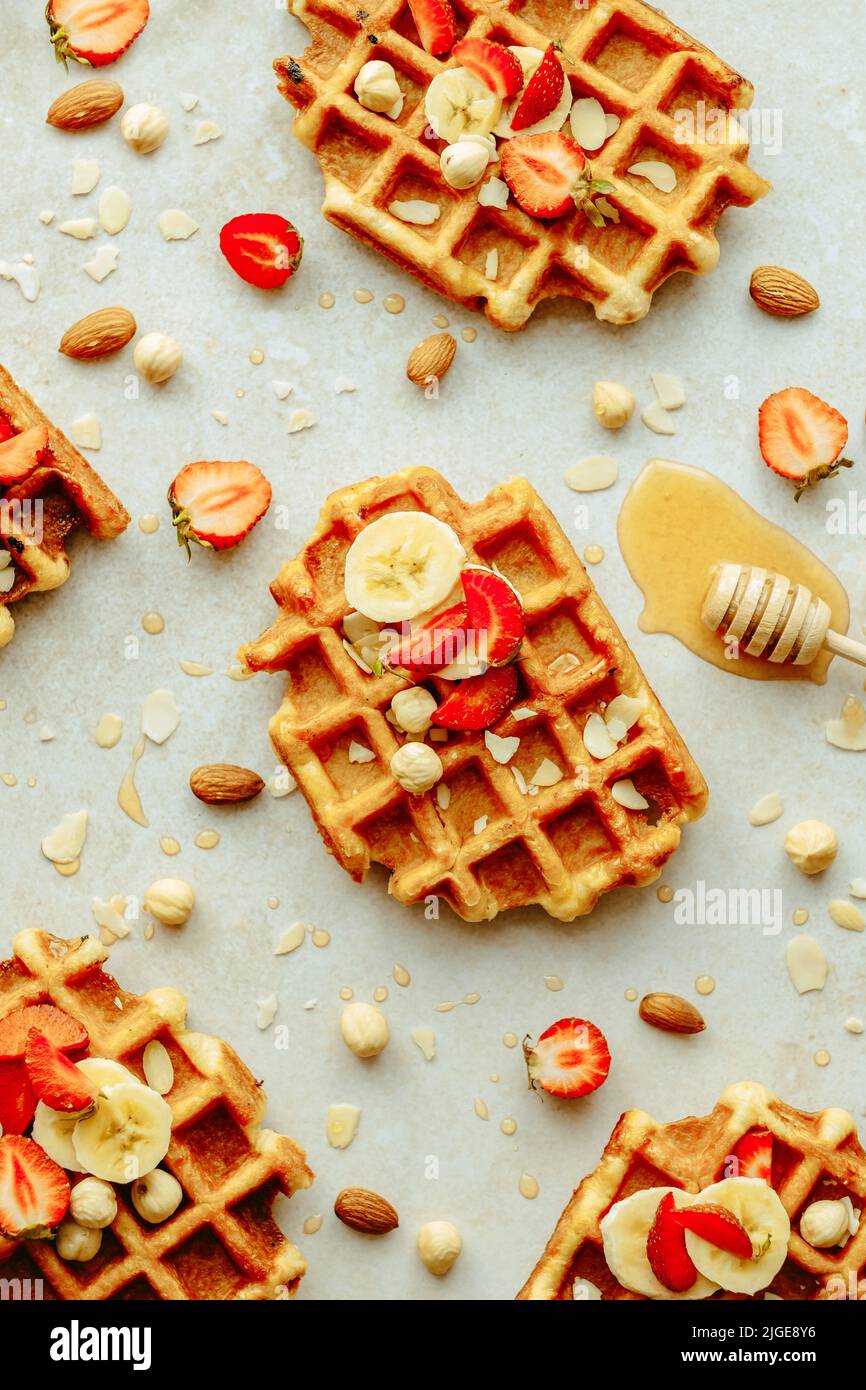 Top view traditional Belgian waffle with fresh fruit, maple syrup and nuts. Flat lay. Summer breakfast, cooking concept Stock Photo