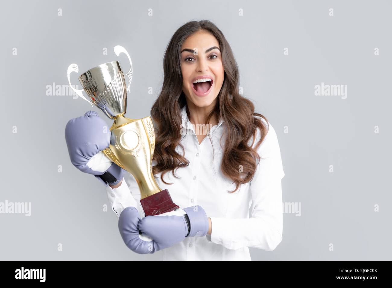 Woman in boxing gloves hold champion winner cup, trophy. Winning