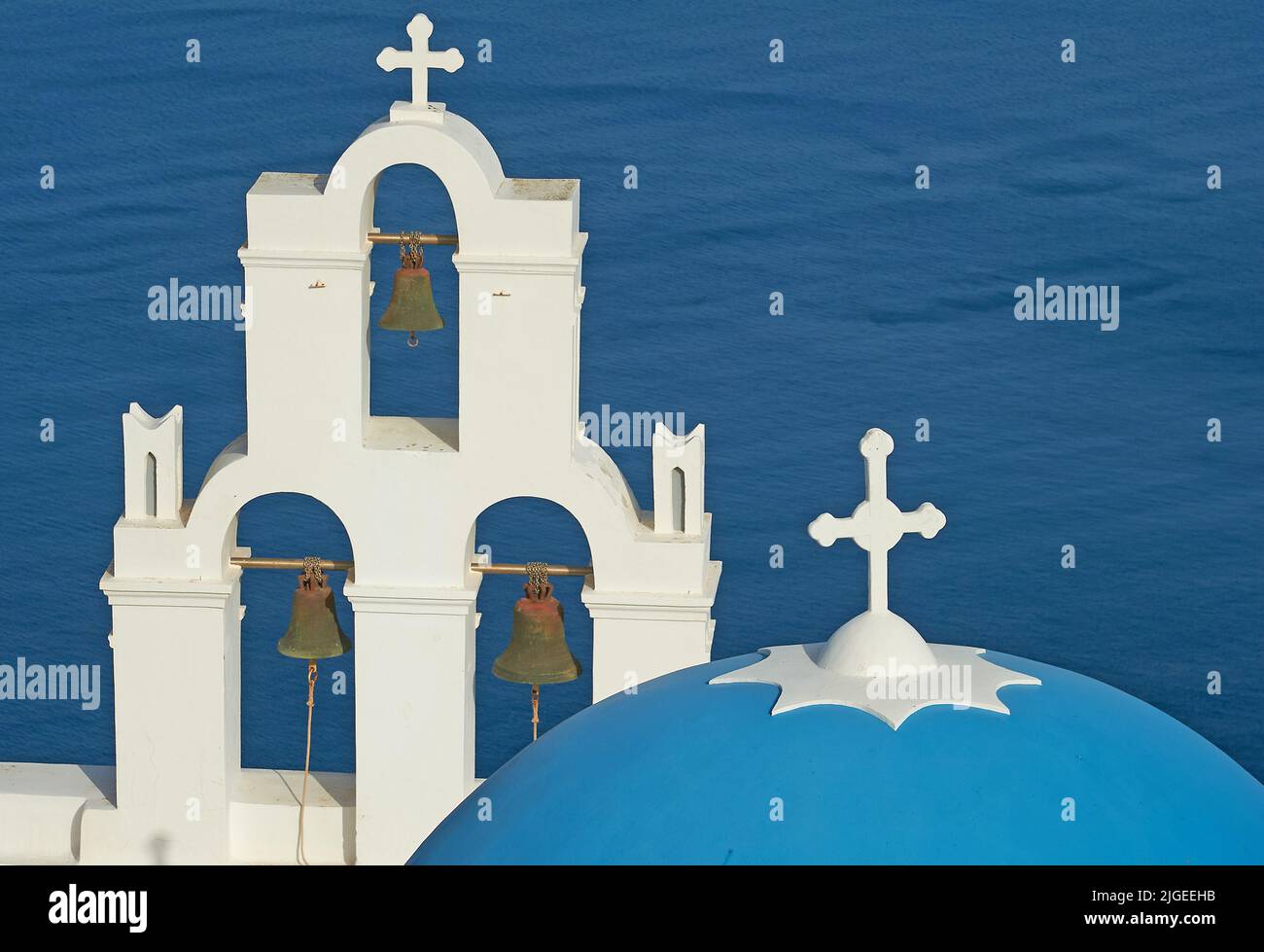 Santorini, Greece and the blue dome and bell tower of the Greek Orthodox church commonly known as the Three Bells of Thira (Fira) Stock Photo