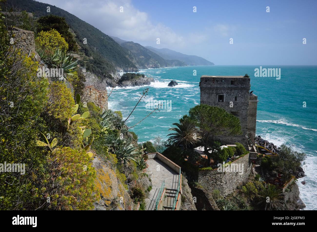 View of old stone fortress on cliff on Mediterranean sea Cinque Terre,  Riomaggiore, Liguria, Italy. Bay with bright azure water and layers of rocks Stock Photo
