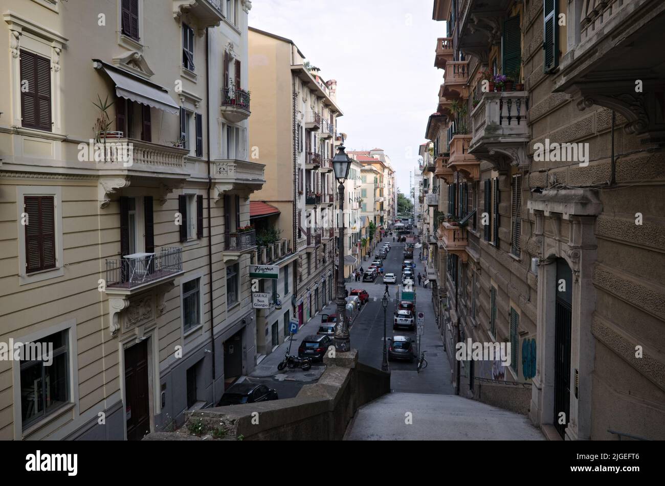 La Spezia, Italy - April, 2022: Top view from descent along stone stairs with lamppost to Scalinata S. Giorgio street. Straight narrow street Stock Photo