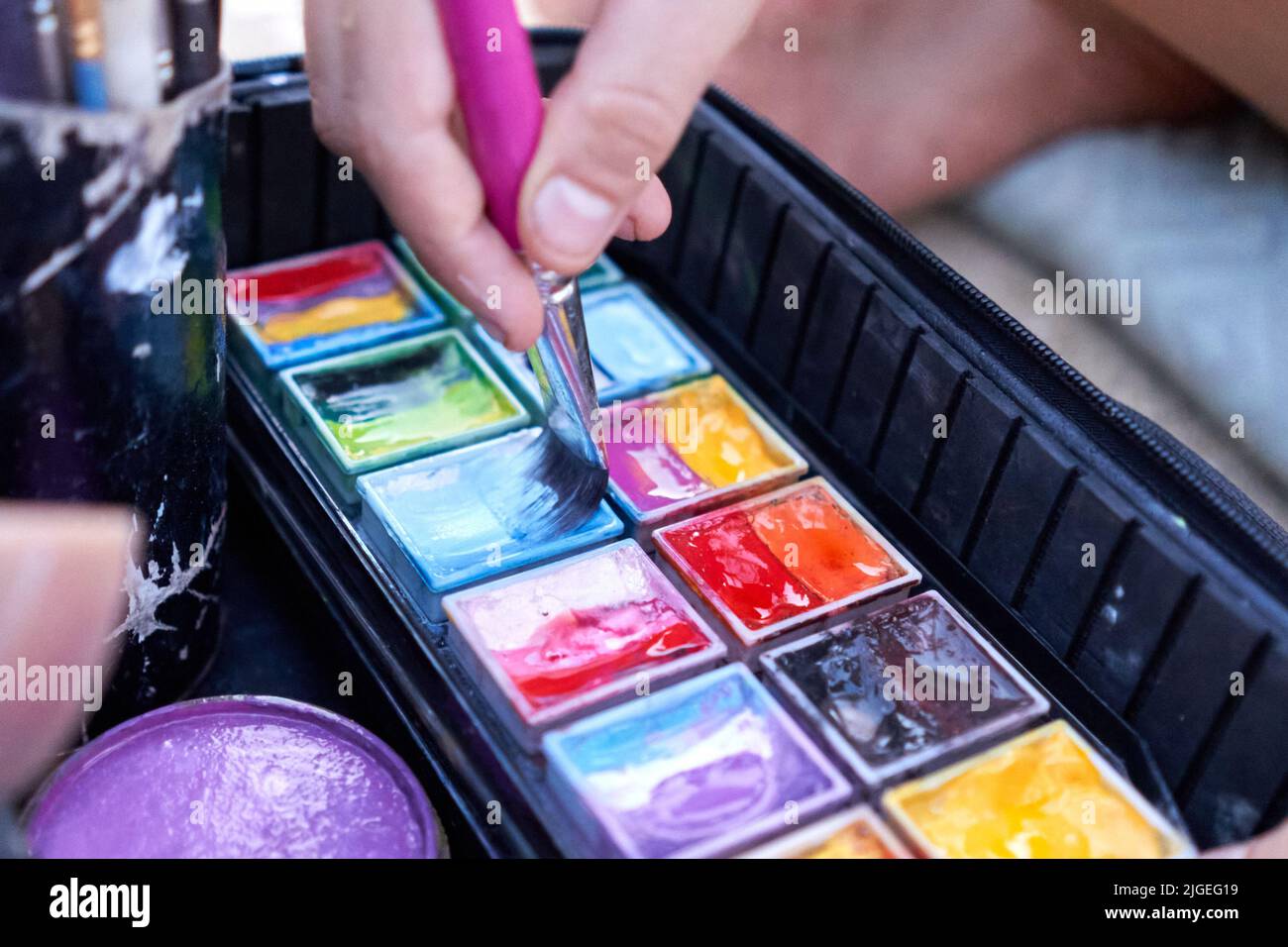 Artist dipping a paintbrush in paint to make a body paint work Stock Photo Alamy