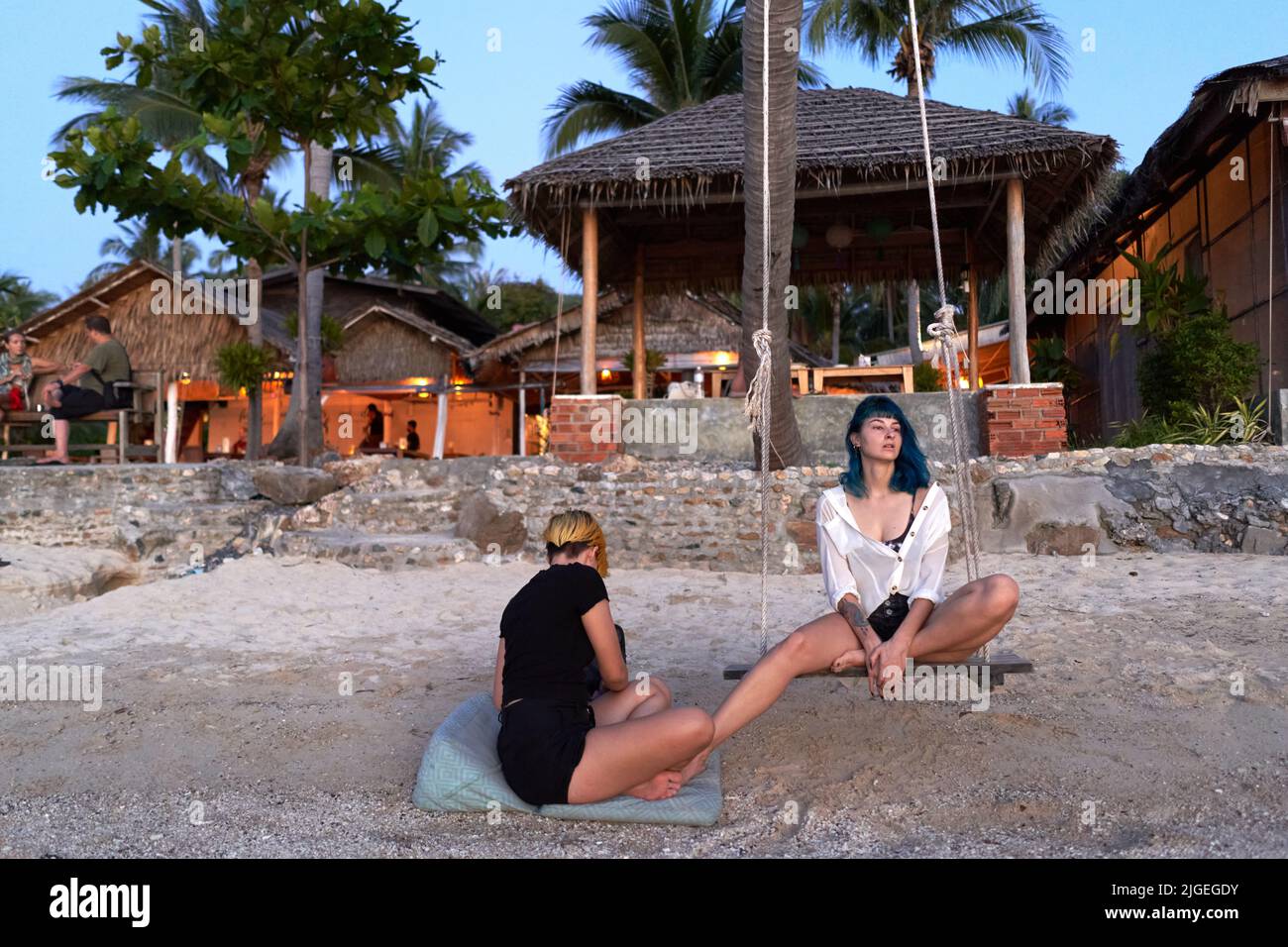 Two relaxed friends on the beach during a body paint session Stock Photo