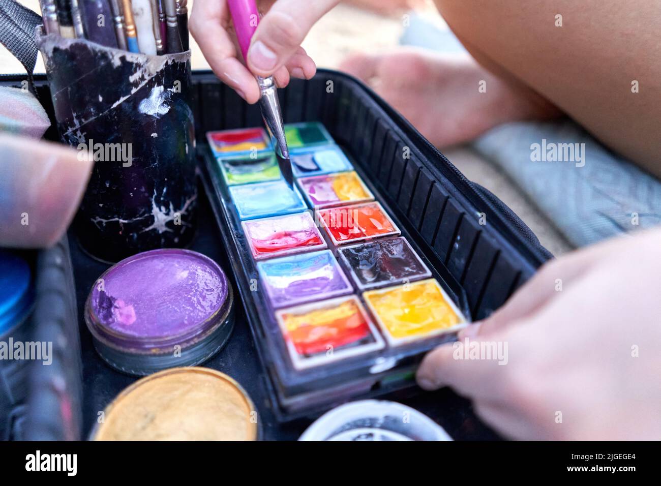 Artist using a paintbrush in paint to make a body paint work Stock Photo